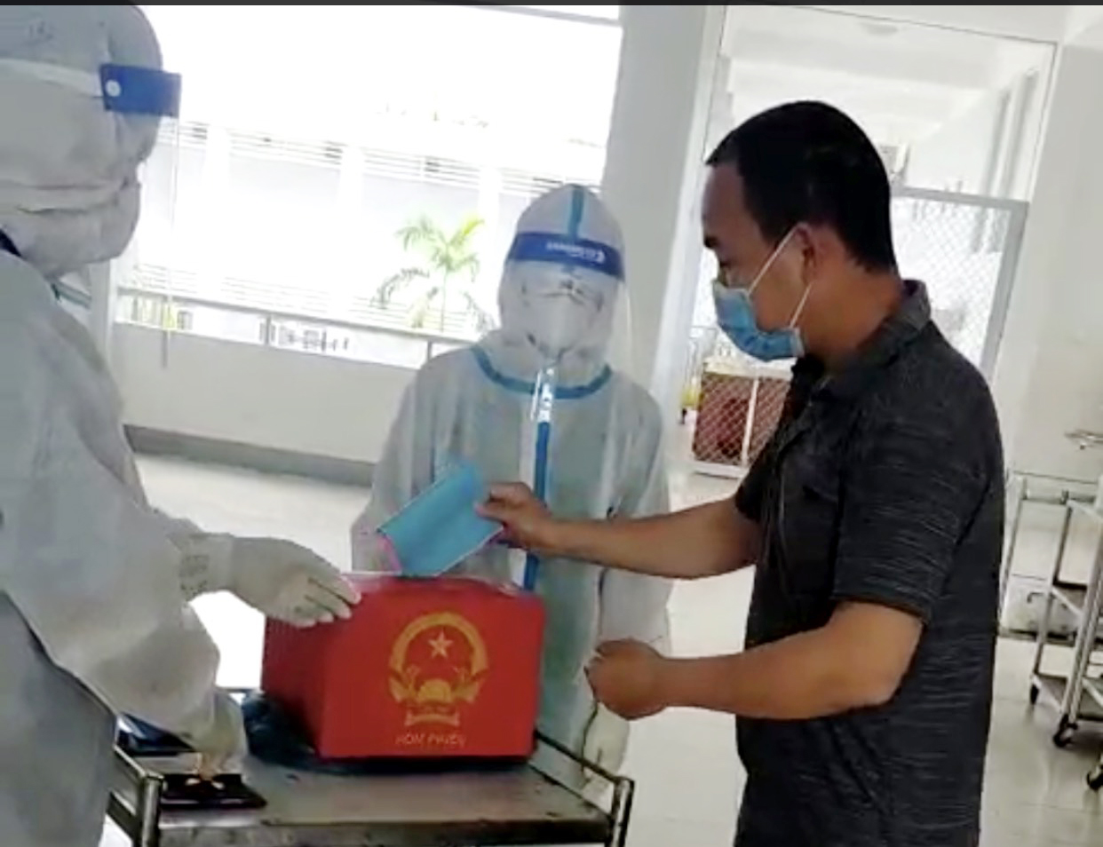 Cử tri trong khu điều trị cách ly Trung tâm Y tế huyện Long Điền bỏ phiếu bầu cử. Ảnh Minh Thanh