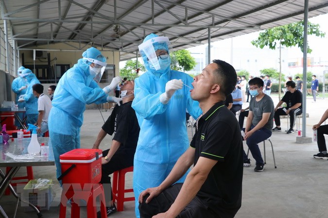 Lực lượng y tế lấy mẫu xét nghiệm virus SARS-CoV-2 đối với công nhân và người lao trong khu kinh tế, khu công nghiệp trên địa bàn TP. Hải Phòng. Ảnh: TTXVN