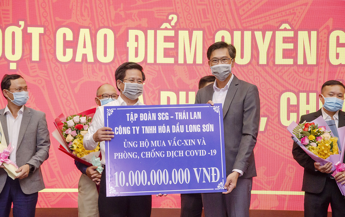 Đại diện Tập Đoàn SCG - Thái Lan (Công ty TNHH Hóa dầu Long Sơn) trao bảng tượng trưng ủng hộ 10 tỷ đồng mua vaccine và phòng, chống dịch bệnh COVID-19 cho UBMTTQ Việt Nam tỉnh.