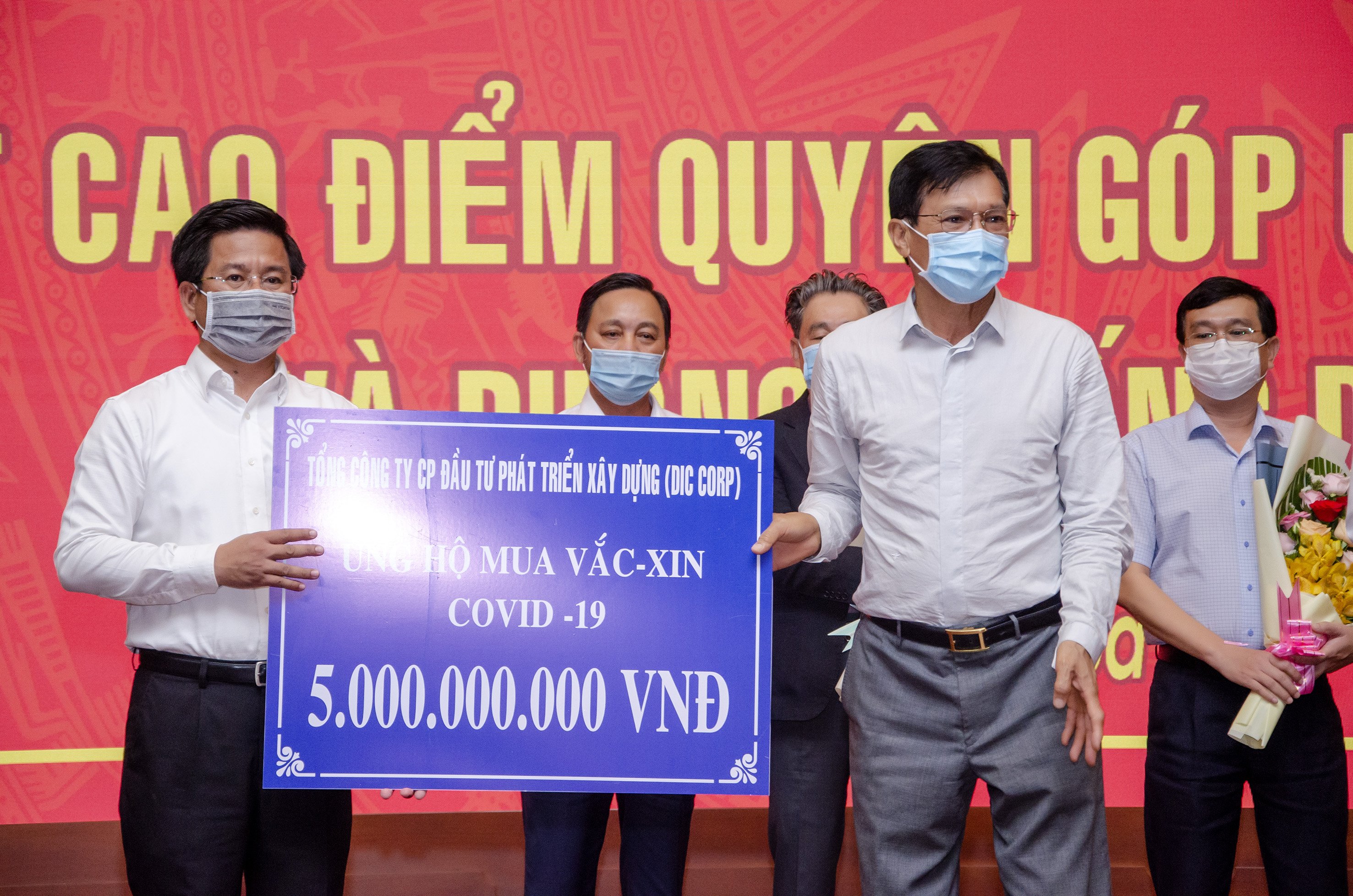 Đại diện Tổng Công ty CP Đầu tư Phát triển Xây dựng (DIC CORP) trao bảng tượng trưng ủng hộ 5 tỷ đồng mua vaccine và phòng, chống dịch bệnh COVID-19 cho UBMTTQ Việt Nam tỉnh.
