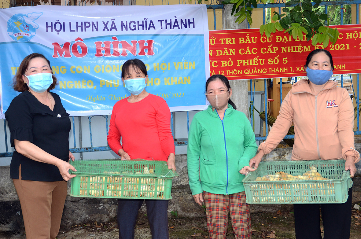 Bà Huỳnh Thị Hoa (bìa trái), Chủ tịch Hội LHPN xã Nghĩa Thành trao gà giống cho hội viên phụ nữ khó khăn, khuyết tật.