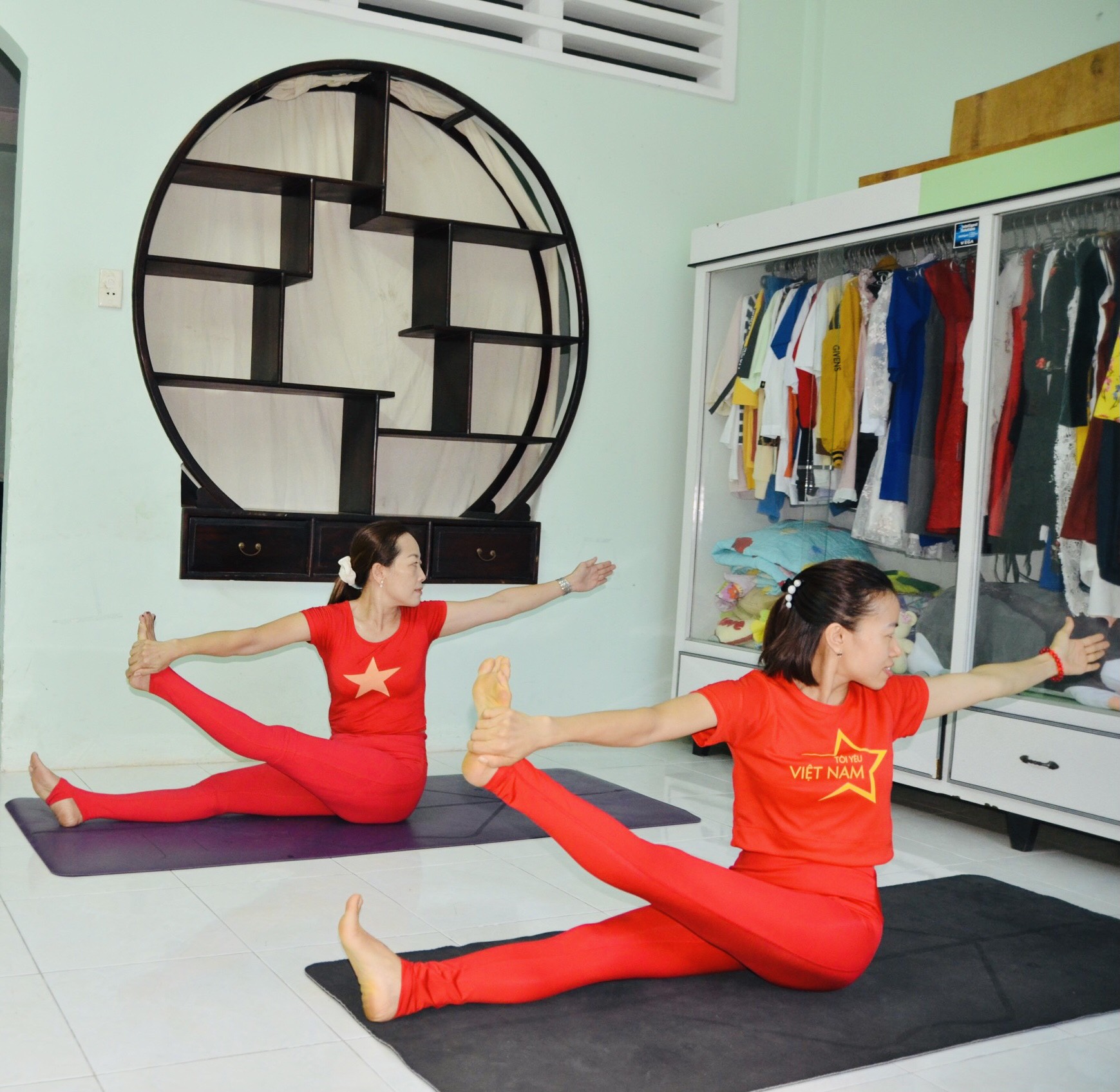 Chị Vũ Thị Kim Nhung (trái) và chị Lê Thị Hằng tập yoga online tại nhà để phòng tránh dịch.