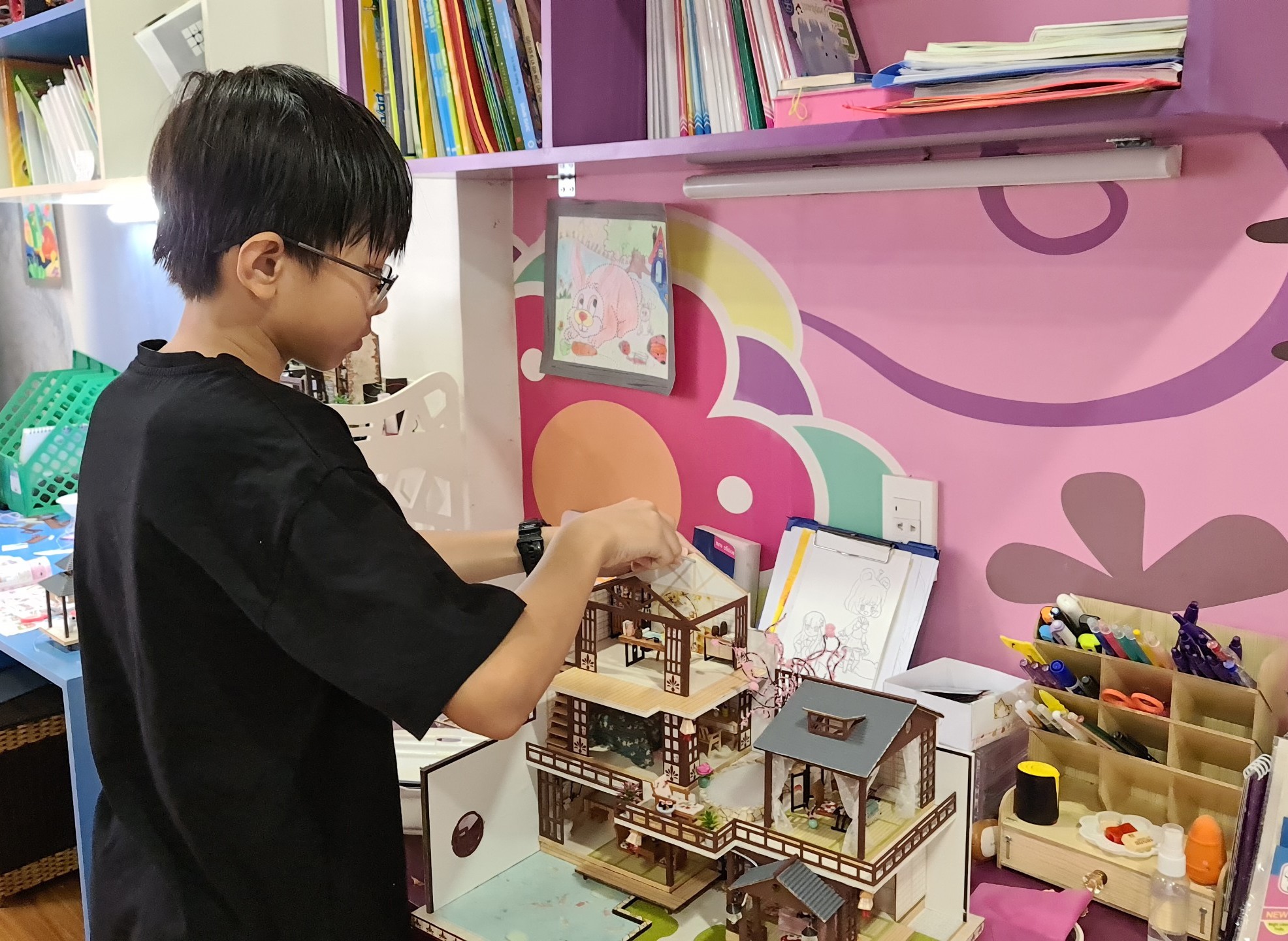 Mạc Huỳnh Minh Khôi miệt mài thực hiện mô hình nhà gỗ  để bán gây quỹ vắc xin phòng COVID-19.