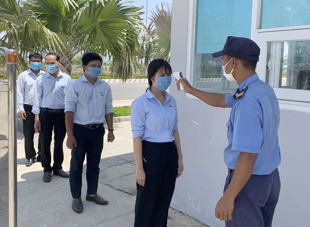 Bảo vệ Công ty CP KCN Tín Nghĩa Phương Đông kiểm tra thân nhiệt của nhân viên tại cổng vào công ty.