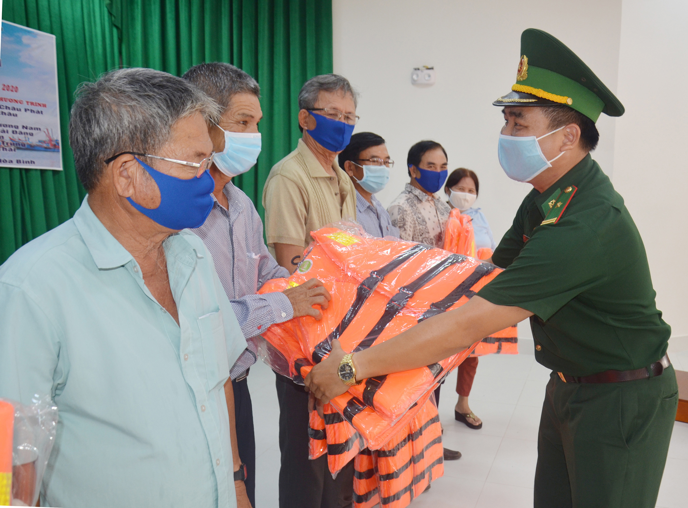 Cán bộ, chiến sĩ Đồn Biên phòng Phước Tỉnh tặng áo phao cho ngư dân.