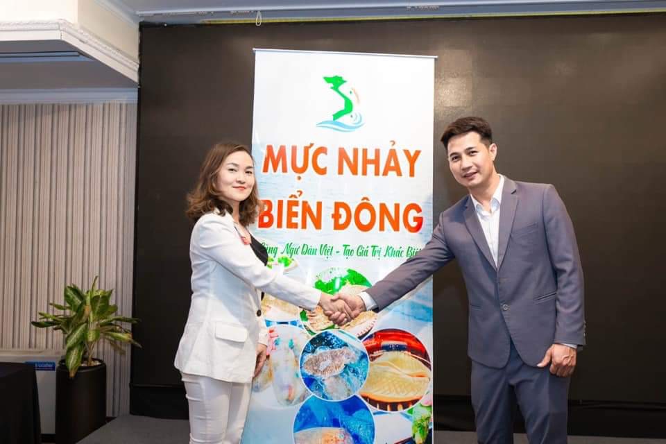 Anh Nguyễn Bá Ngọc, Giám đốc Công ty CP mực nhảy Biển Đông bắt tay hợp tác với 1 đối tác trong việc phân phối sản phẩm mực nhảy.