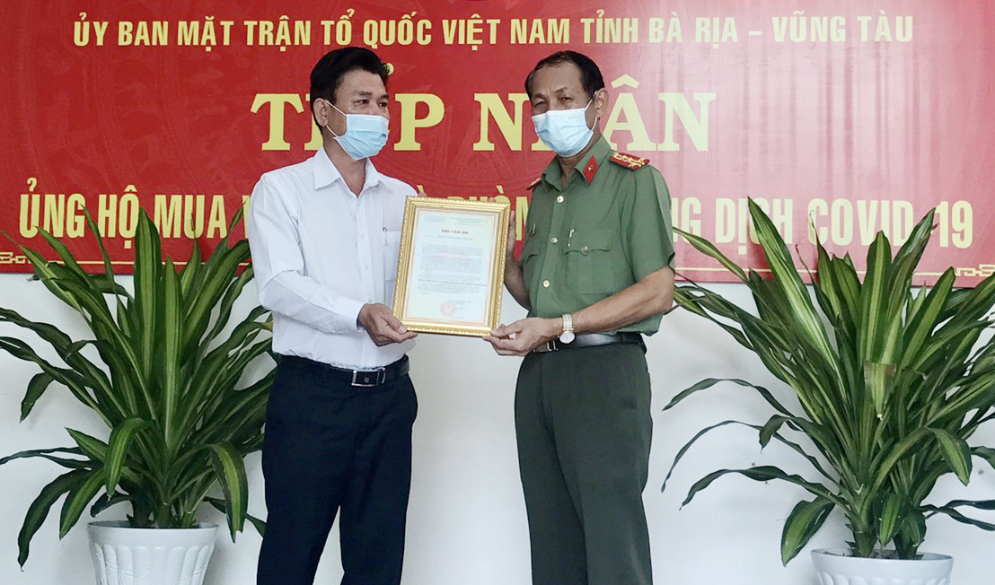 Ông Trần Văn Lợi, Phó Chủ tịch UBMTTQ Việt Nam tỉnh trao Thư cảm ơn tới ông Bùi Văn Thảo, Giám đốc Công an tỉnh vì đã ủng hộ Quỹ vắc xin và phòng, chống dịch COVID-19.