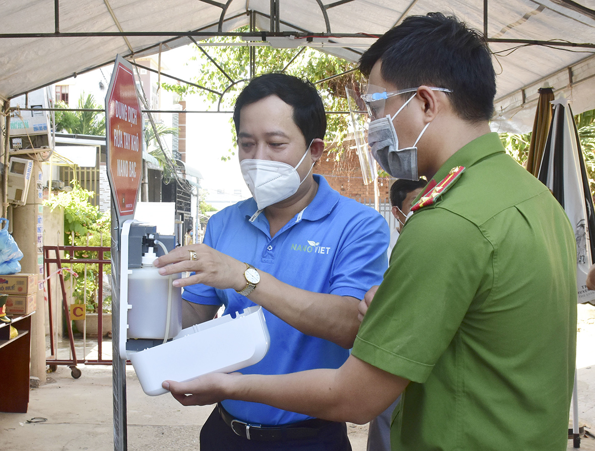 Công ty CP Công nghệ môi trường Nano Việt hướng dẫn lực lượng làm nhiệm vụ ở khu vực phong tỏa cách sử dụng máy rửa tay sát khuẩn nano bạc tự động.