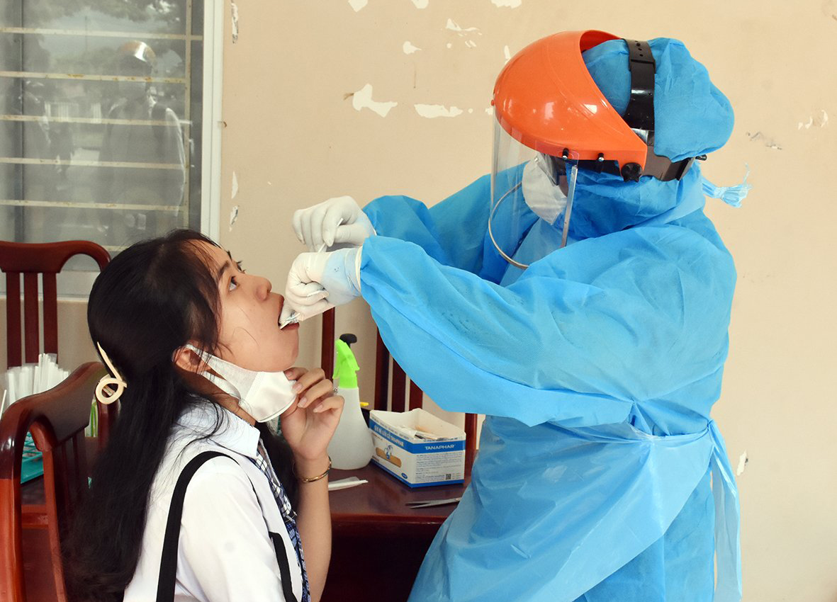 Nhân viên y tế lấy mẫu xét nghiệm COVID-19 cho HS tại điểm thi Trường THPT Minh Đạm, huyện Long Điền.
