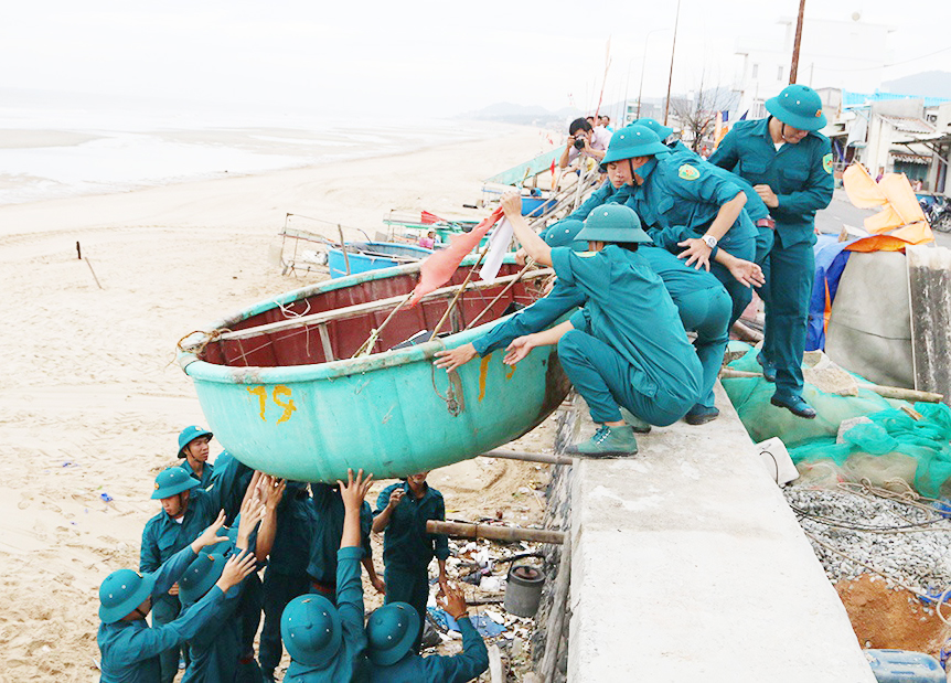 Lực lượng DQTV biển TT. Phước Hải, huyện Đất Đỏ hỗ trợ ngư dân đưa thuyền thúng vào bờ để tránh trú bão.