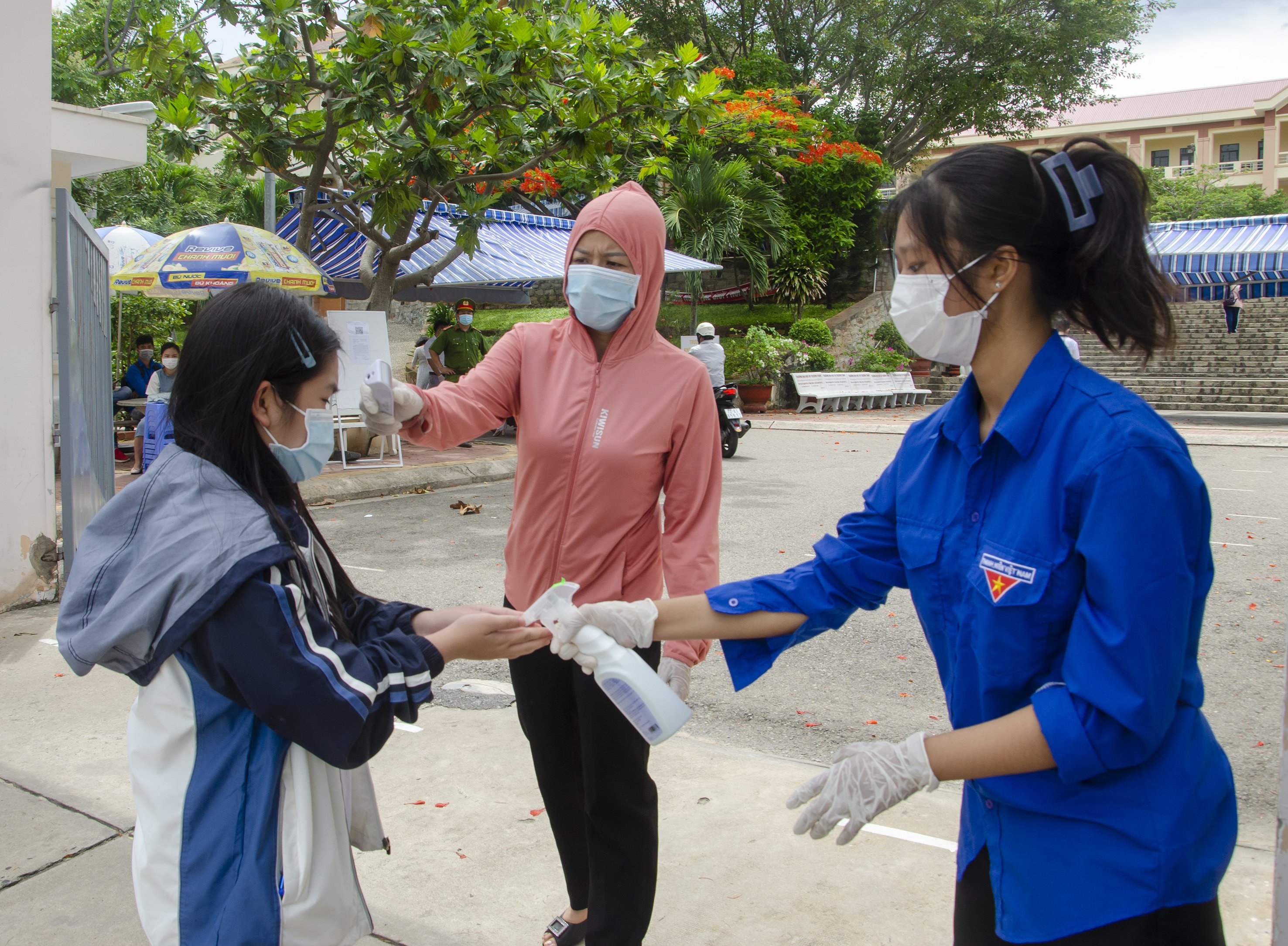 Lực lượng làm nhiệm vụ tại điểm thi Trường THPT Vũng Tàu đo thân nhiệt và giúp TS rửa tay sát khuẩn trong ngày thi đầu tiên. 