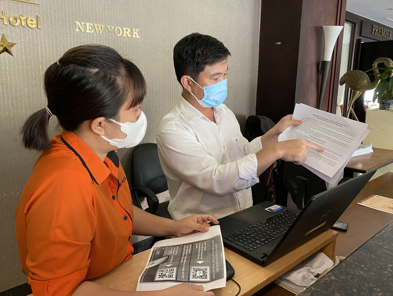 Chuyên viên Sở Du lịch (bên phải) hướng dẫn nhân viên khách sạn Kiều Anh cách cài đặt sử dụng ứng dụng “Du lịch Việt Nam an toàn”.