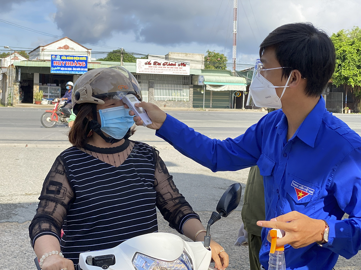 Đoàn viên kiểm tra thân nhiệt người vào chợ Láng Cát.