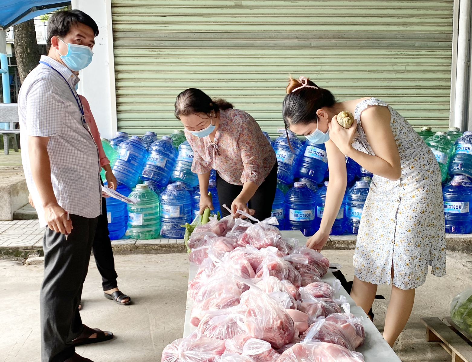 Người dân trong khu cách ly chợ đầu mối Lam Sơn nhận thịt heo về chế biến bữa ăn.