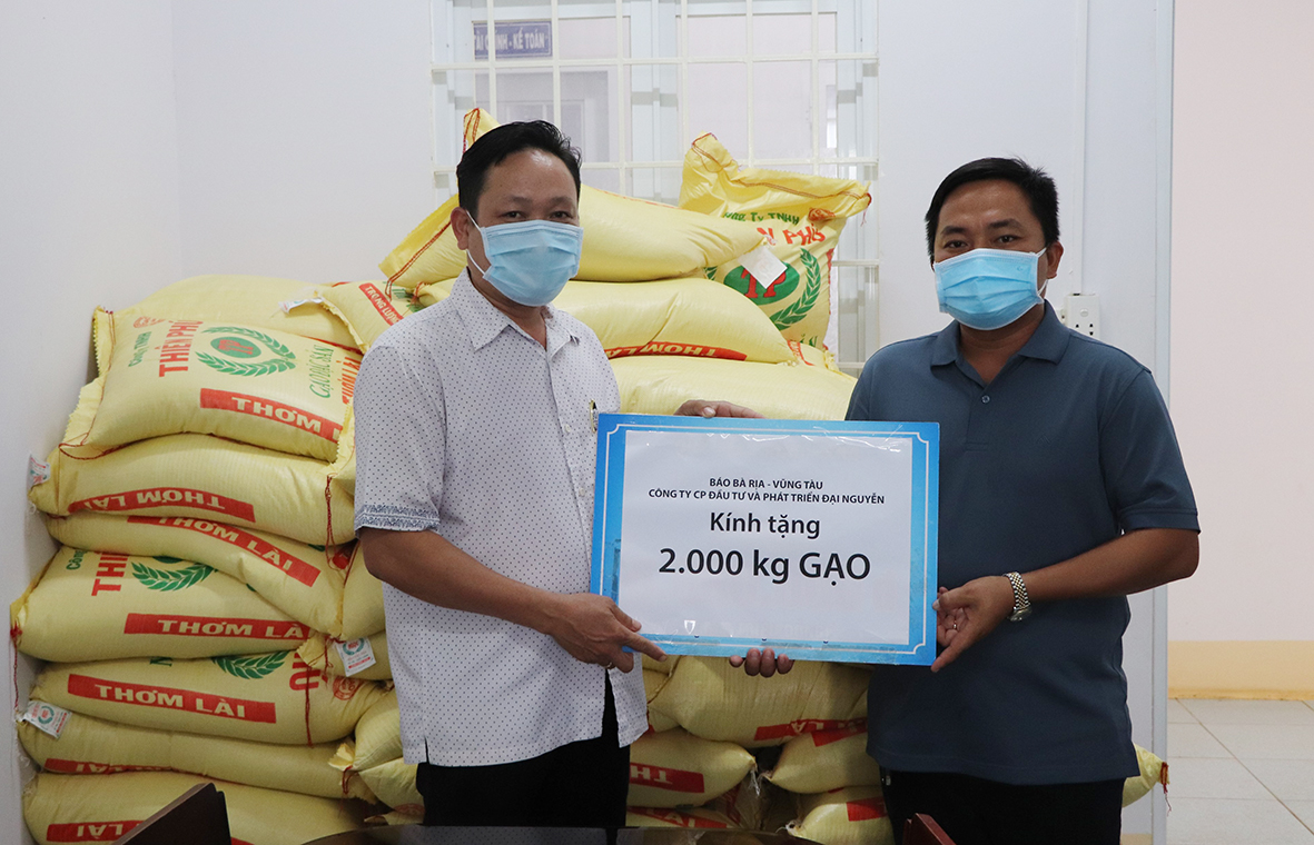 Ông Trần văn Tuấn (bên phải), Phó Giám đốc Công ty CP Đầu tư – Phát triển Đại Nguyên trao 2 tấn gạo cho xã Láng Lớn.
