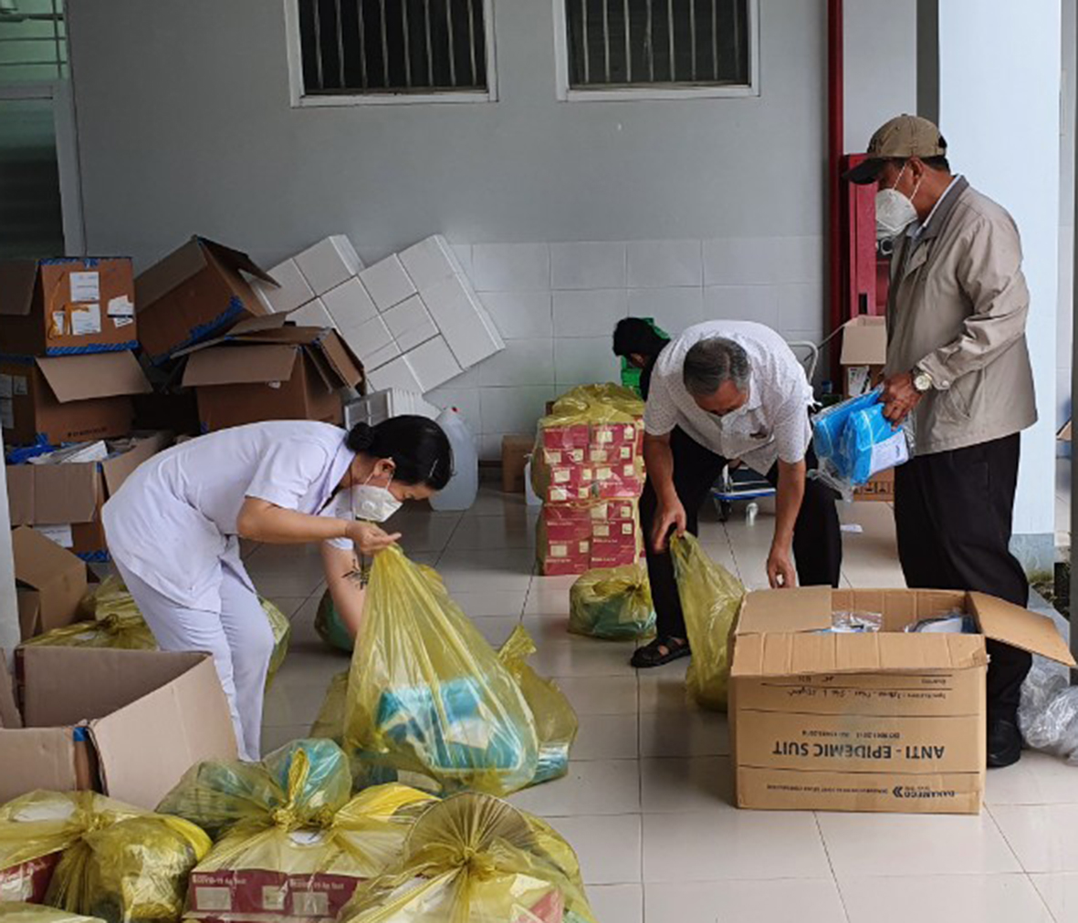 Ông Dương Văn Muôn (áo trắng), Giám đốc TTYT huyện Long Điền cùng nhân viên y tế trung tâm, gấp rút chuẩn bị hành trang bảo hộ để xuất phát tới điểm lấy mẫu.