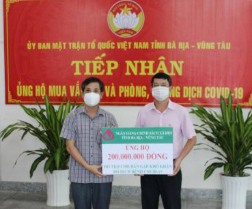 Đại diện NHCSXH tỉnh (bìa phải) trao bảng tượng trưng  số tiền hỗ trợ người dân gặp khó khăn do dịch bệnh COVID-19 cho UBMTTQ Việt Nam tỉnh.