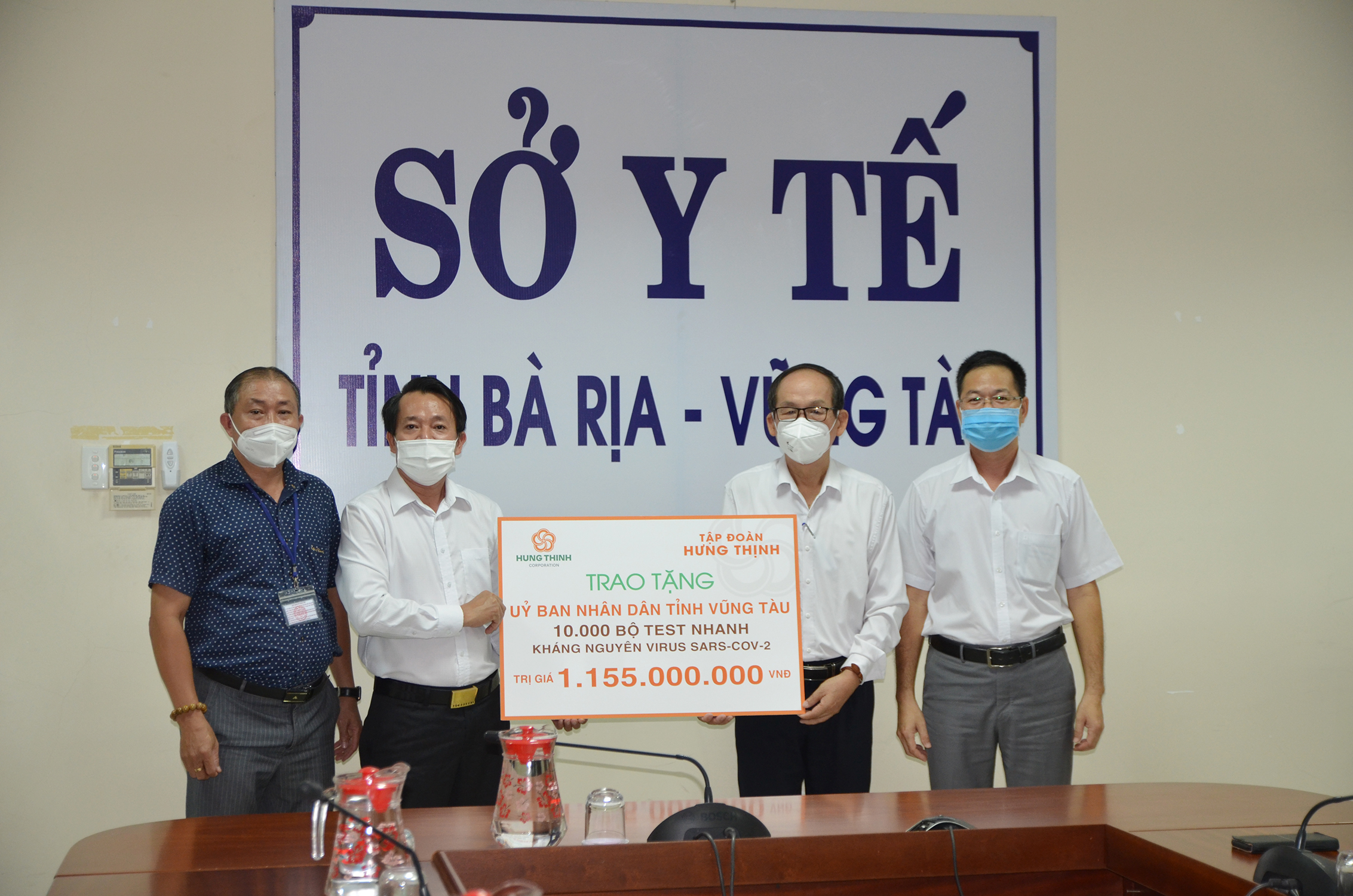 Bác sĩ Lương Văn Quang (thứ 2 từ phải qua), Phó Giám đốc Sở Y tế tiếp nhận bảng tượng trưng tài trợ 10 ngàn bộ test nhanh SARS-CoV-2 từ Tập đoàn Hưng Thịnh.