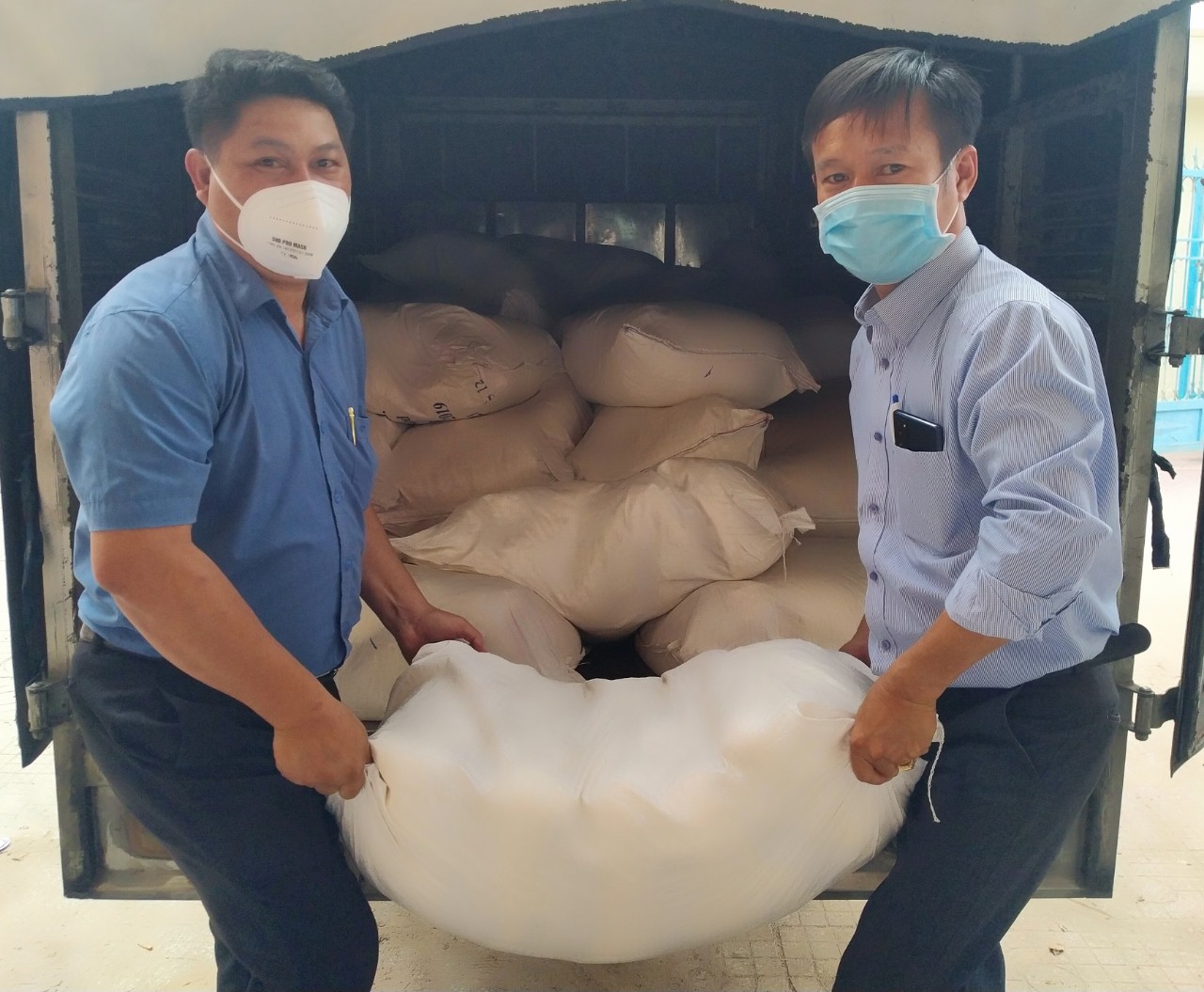 Đại diện lãnh đạo xã Bình Châu (bìa trái) nhận gạo cho hộ nghèo, người có hoàn cảnh khó khăn từ UBMTTQ Việt Nam huyện Xuyên Mộc.