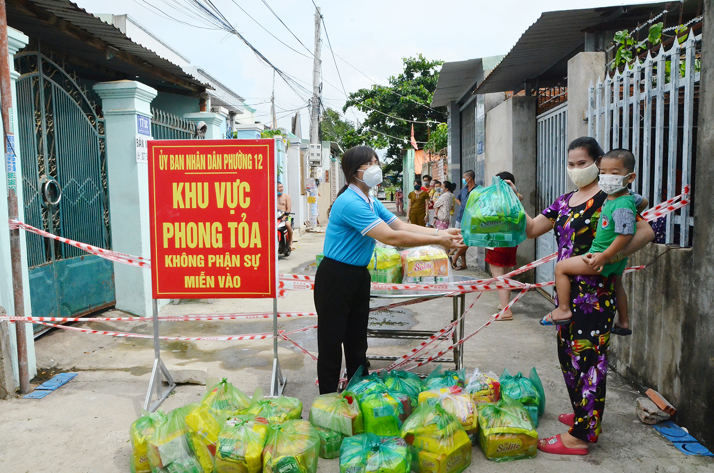 Bà Đỗ Thị Chi, Phó Giám đốc Nhà thiếu nhi tỉnh trao quà “San sẻ yêu thương - Đẩy lùi COVID” cho trẻ em trong khu phong tỏa, hẻm 17, Nguyễn Gia Thiều, phường 12, TP.Vũng Tàu.