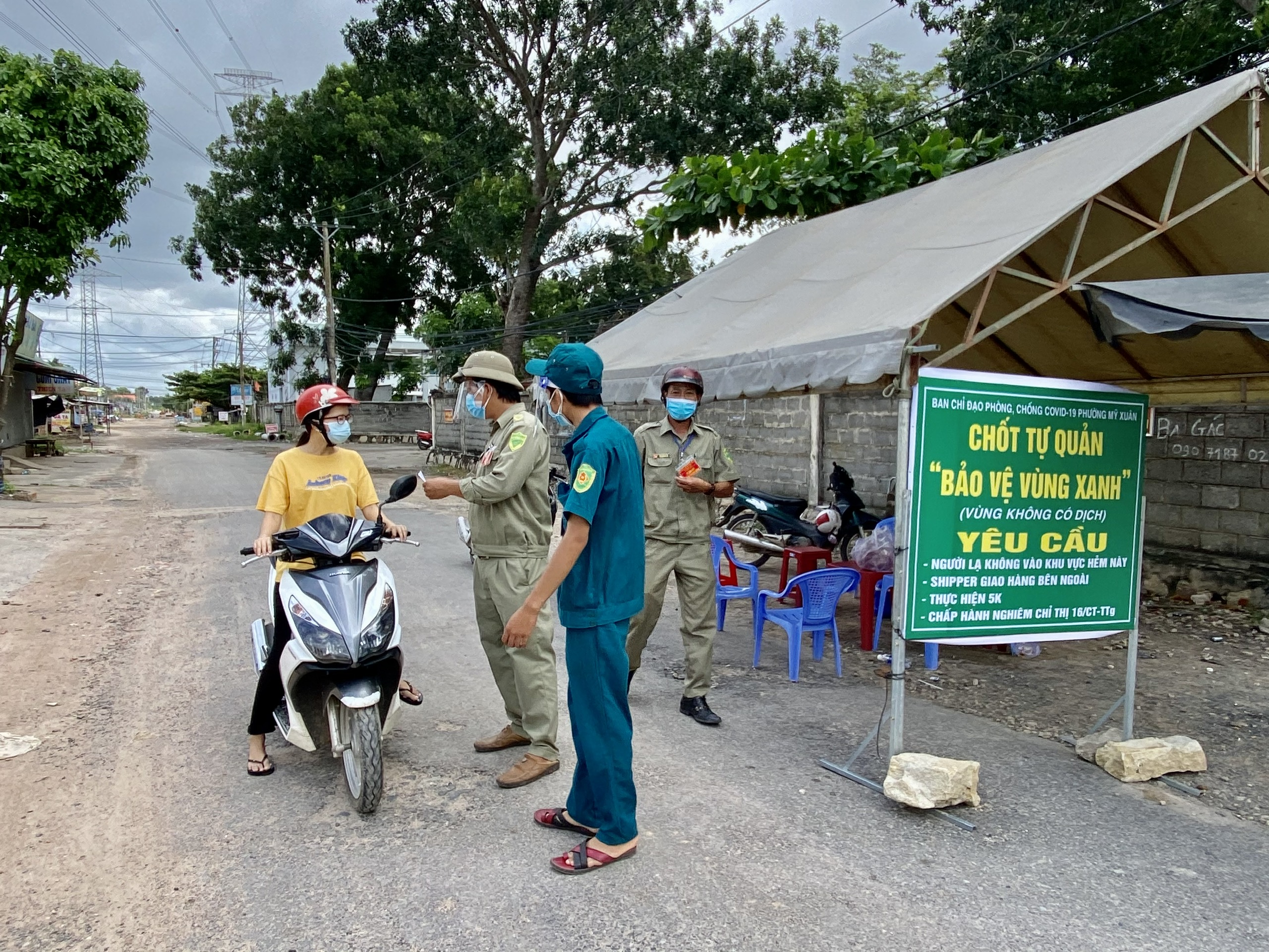 Lực lượng chức năng kiểm tra giấy tờ người dân khi ra đường tại chốt bảo vệ vùng xanh trên địa bàn  phường Mỹ Xuân (TX. Phú Mỹ). Ảnh: QUANG VŨ