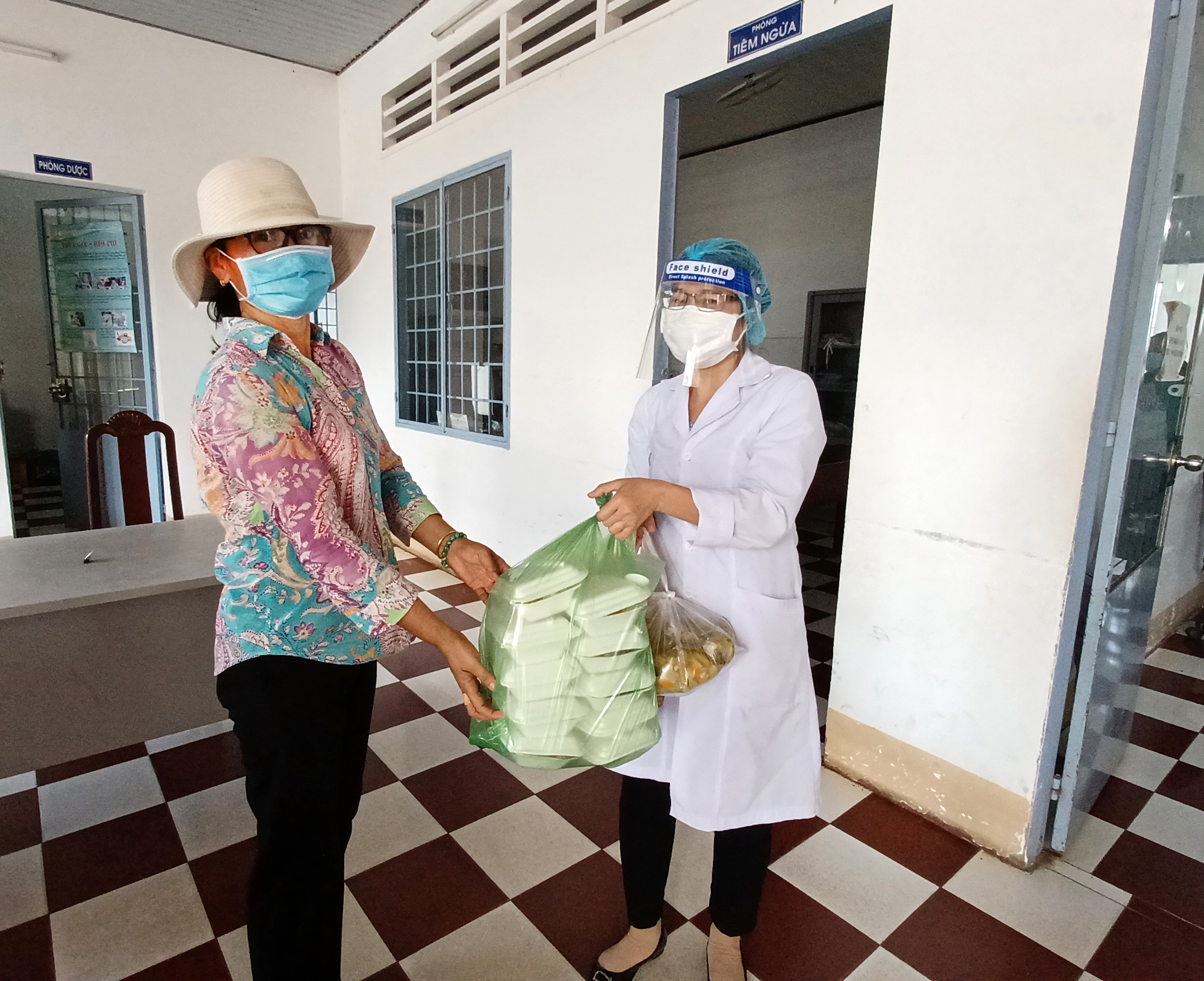 Chị Bùi Thị Kim Thủy, Chủ tịch Hội LHPN thị trấn Đất Đỏ đưa cơm trưa đến cho nhân viên Trạm y tế thị trấn Đất Đỏ.