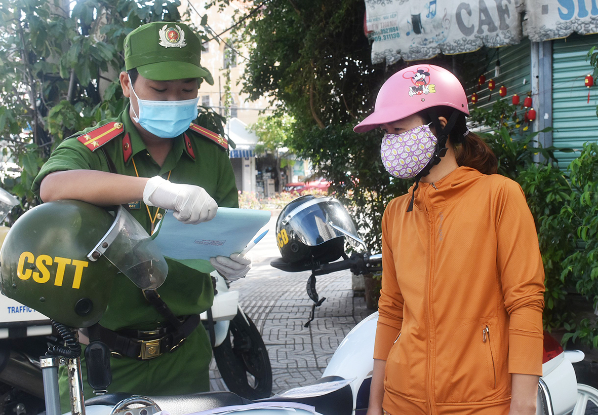 Lực lượng Công an TP.Vũng Tàu đọc biên bản vi phạm cho một người ra đường không cần thiết tại chốt kiểm tra đường Nguyễn Hữu Cảnh.