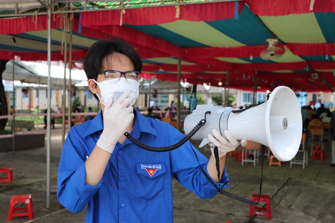 Anh Đỗ Trung Nghĩa, tình nguyện viên xã Kim Long (huyện Châu Đức) hướng dẫn người dân giãn cách chờ khám sàng lọc trước khi tiêm vắc xin.