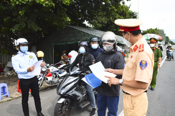 Cảnh sát giao thông kiểm tra giấy tờ của người dân lưu thông qua chốt kiểm dịch khu vực cầu Cỏ May.