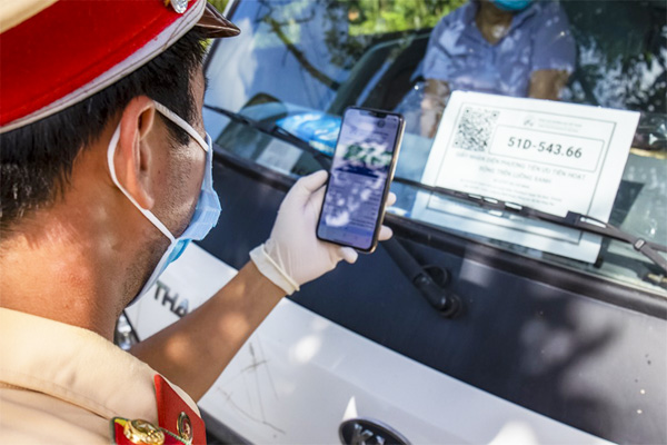 Lực lượng CSGT quét mã QR luồng xanh dán trước xe tải tại chốt kiểm soát y tế QL55.