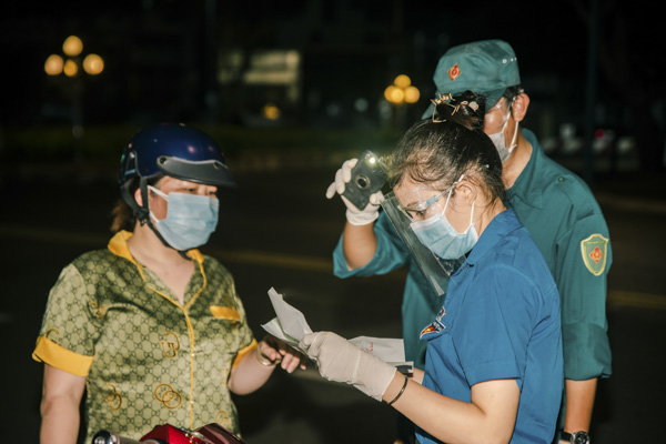 Chị Nguyễn Thị Nhung, đoàn viên thanh niên phường 2, TP. Vũng Tàu hỗ trợ kiểm tra giấy đi đường của người dân tại chốt bảo vệ vùng xanh trên đường Võ Thị Sáu, phường 2. Ảnh: THÁI NGÔ