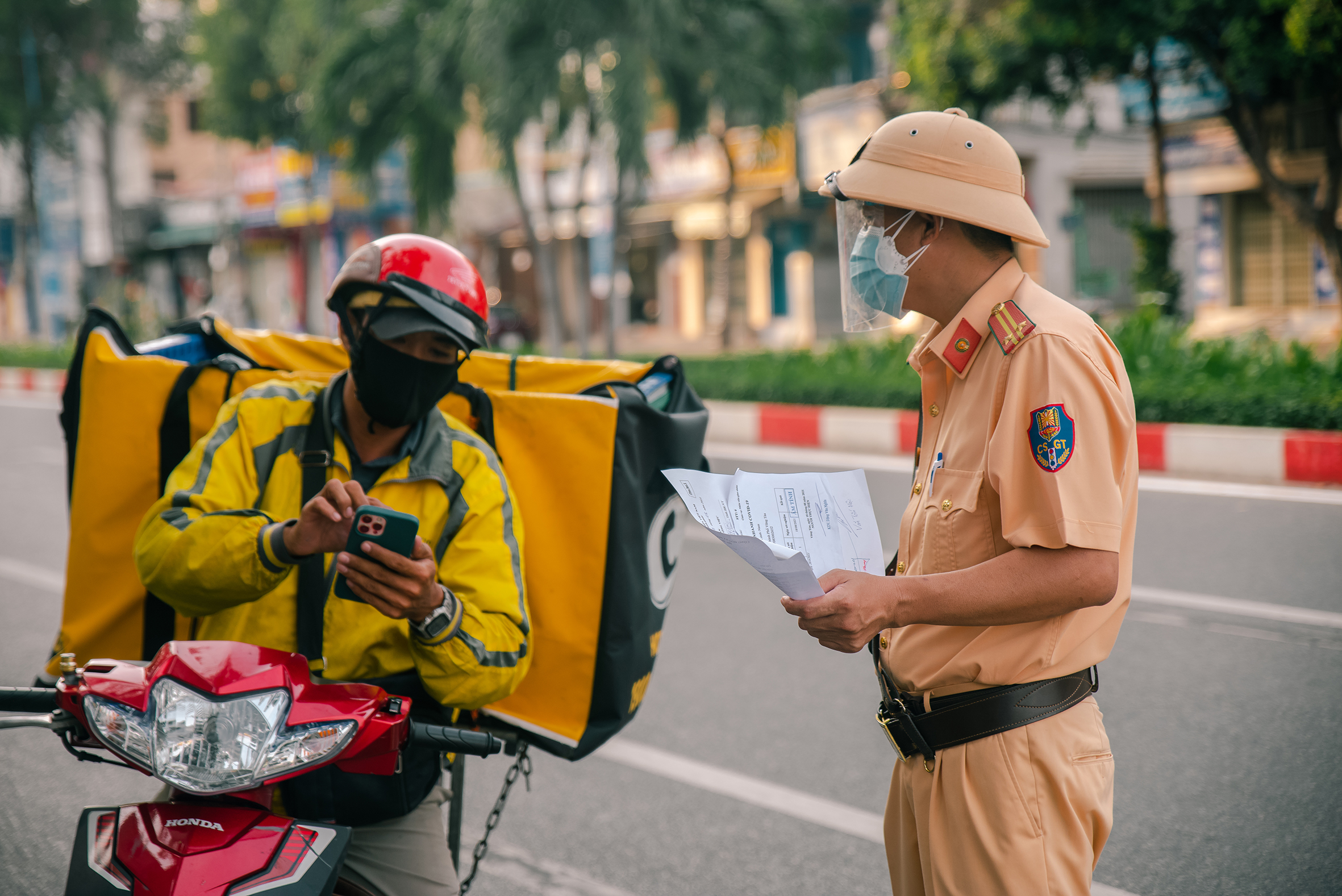 CSGT Công an TP. Vũng Tàu kiểm tra giấy đi đường của một shipper lưu thông trên đường Lê Hồng Phong. Ảnh: QUỐC THÁI