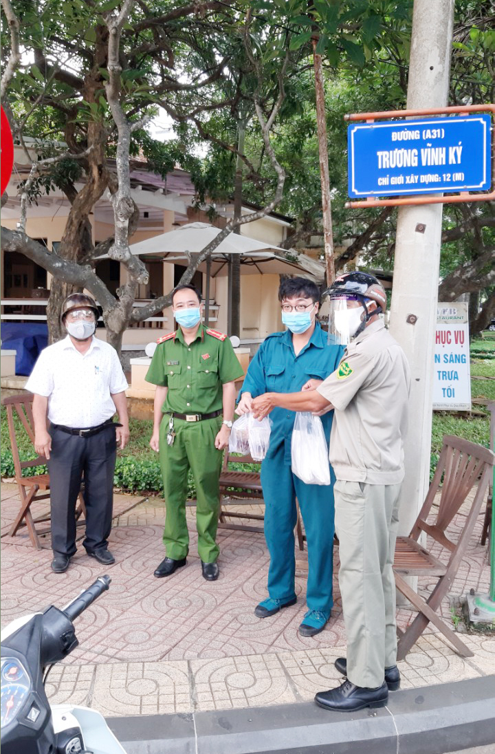 Ông Trịnh Văn Thể (bìa trái) cùng tổ hậu cần khu phố 1, phường 1 tặng suất ăn, nước uống cho những người đang làm nhiệm vụ tại các chốt kiểm soát trên địa bàn phường.