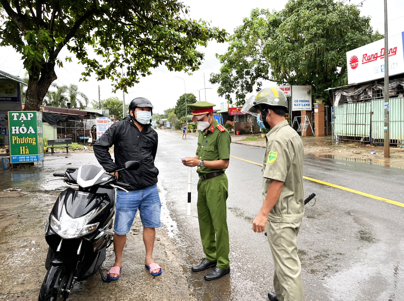 Công an TT. Ngãi Giao và bảo vệ dân phố kiểm tra giấy đi đường của người dân trong thời gian thực hiện giãn cách xã hội theo Chỉ thị 16. Ảnh: NGỌC BÍCH