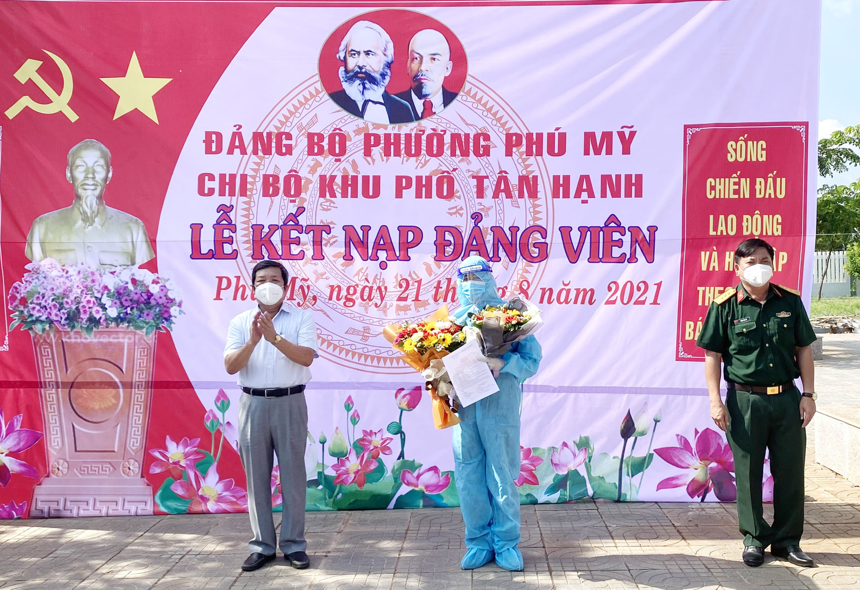 Thượng tá Trần Văn Cư, Chỉ huy trưởng Ban CHQS TX. Phú Mỹ (bìa phải) và ông Châu Văn Măng, Bí thư Đảng ủy phường Phú Mỹ tặng hoa chúc mừng đảng viên Vi Văn Lộc.