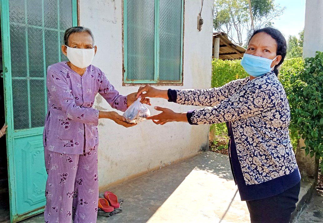 Đại diện Hội phụ nữ trao tặng cá cho cụ già neo đơn  tại khu phố Vinh Thanh (TT.Ngãi Giao). Ảnh: BÍCH NGỌC