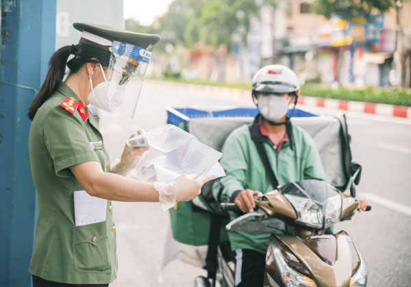 Lực lượng chức năng TP. Vũng Tàu kiểm tra giấy đi đường của một shipper lưu thông trên đường Lê Hồng Phong. Ảnh: QUỐC THÁI