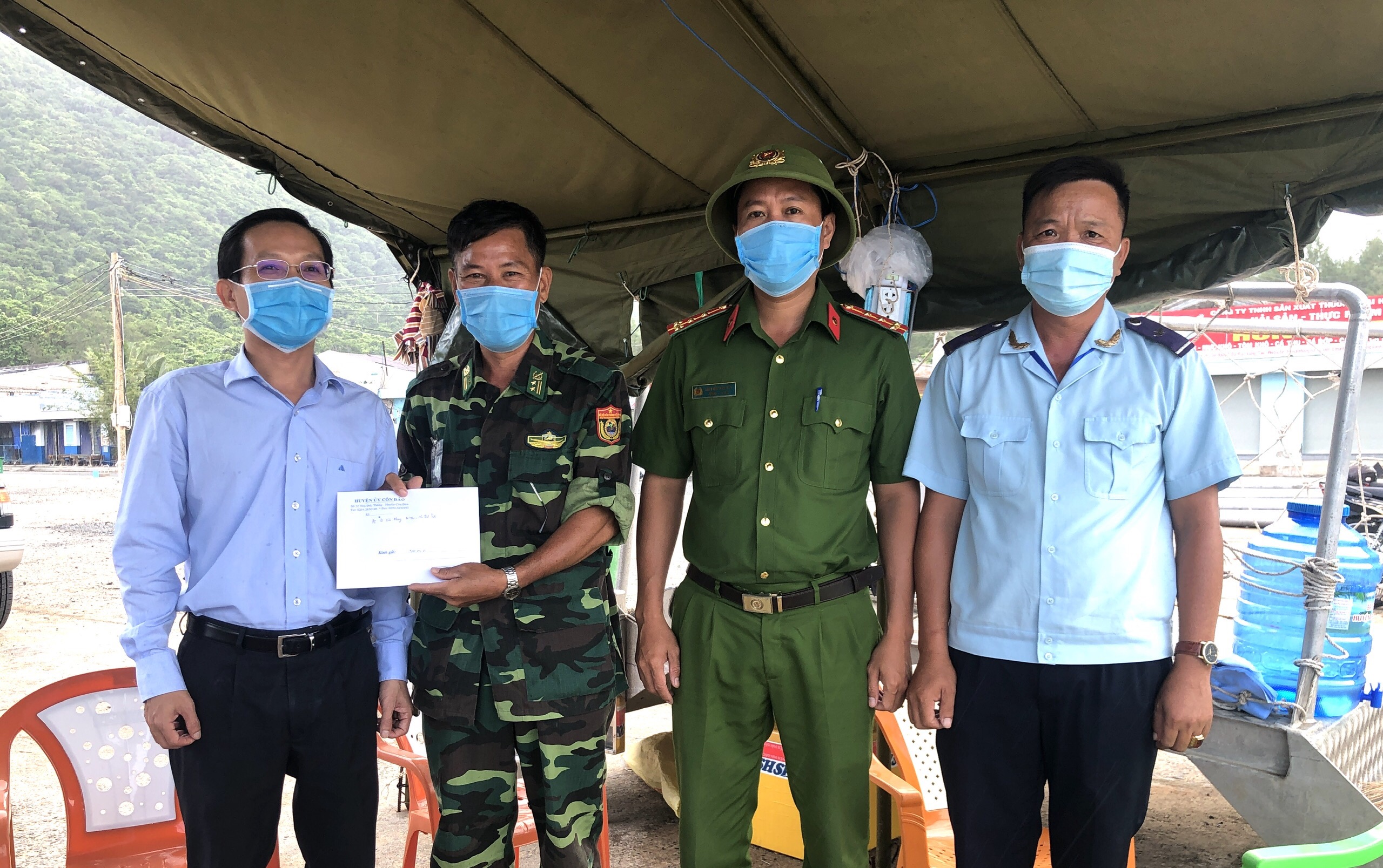 Ông Lê Văn Phong (bìa trái), Bí thư Huyện ủy, Chủ tịch UBND huyện, Trưởng BCĐ Phòng, chống dịch COVID-19 huyện Côn Đảo tặng quà chốt kiểm soát dịch tại Cảng Bến Đầm. Ảnh: MẠNH CƯỜNG