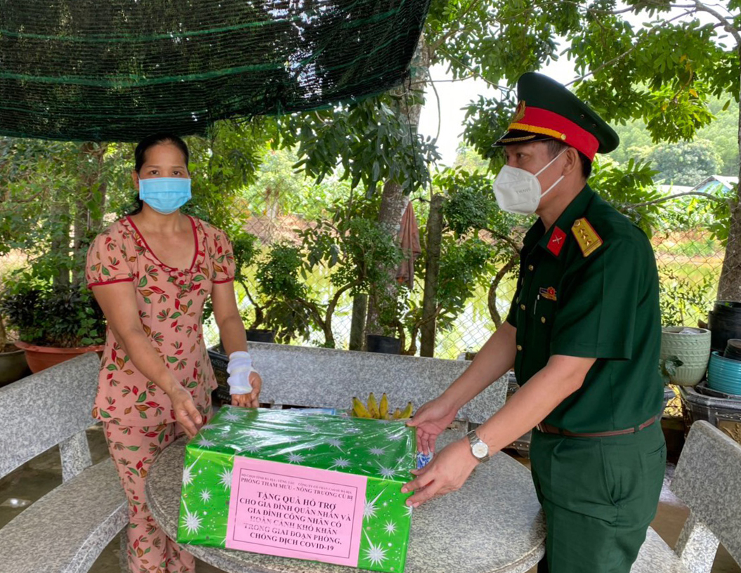 Đại diện Phòng Tham mưu Bộ CHQS tỉnh tặng quà cho gia đình công nhân viên nông trường cao su Cù Bị có hoàn cảnh khó khăn do ảnh hưởng của dịch. Ảnh: MINH NHÂN