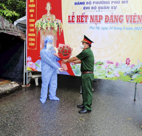 Thượng tá Trần Văn Cư, Chỉ huy trưởng Ban chỉ huy Quân sự TX. Phú Mỹ tặng hoa chúc mừng Đỗ Hữu Nghĩa được kết nạp Đảng ngay tại chốt bảo vệ vùng xanh - nơi anh đang làm nhiệm vụ.