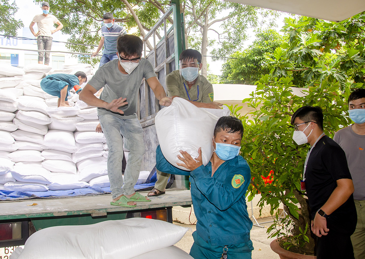 Lực lượng chức năng, tình nguyện viên vận chuyển, tập kết 15 tấn gạo hỗ trợ của Chính phủ đến trụ sở UBND phường 7, TP.Vũng Tàu sáng 27/8. Ảnh: MẠNH THẮNG