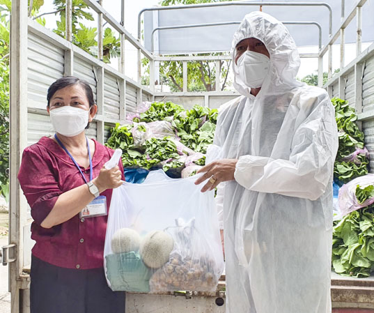 Trung tá Đoàn Xuân Sơn, Chính ủy Trung đoàn Minh Đạm trao tặng túi an sinh cho các hộ dân trong khu vực phong tỏa phòng, chống dịch thông qua UBMTTQ Việt Nam TT. Long Hải.