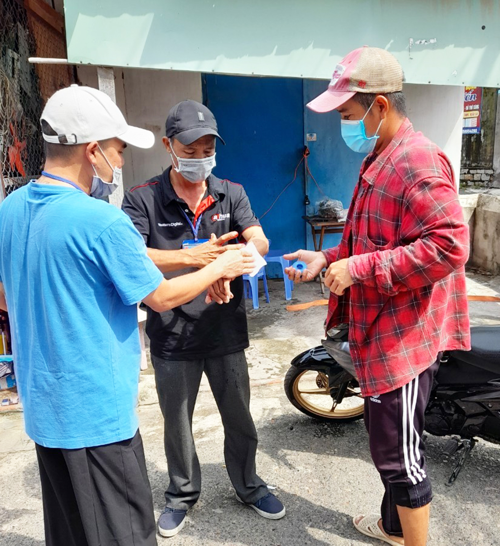 Ông Hải (giữa) đang được người tham gia trực chốt băng bó vết thương sau khi bị Trung chém.