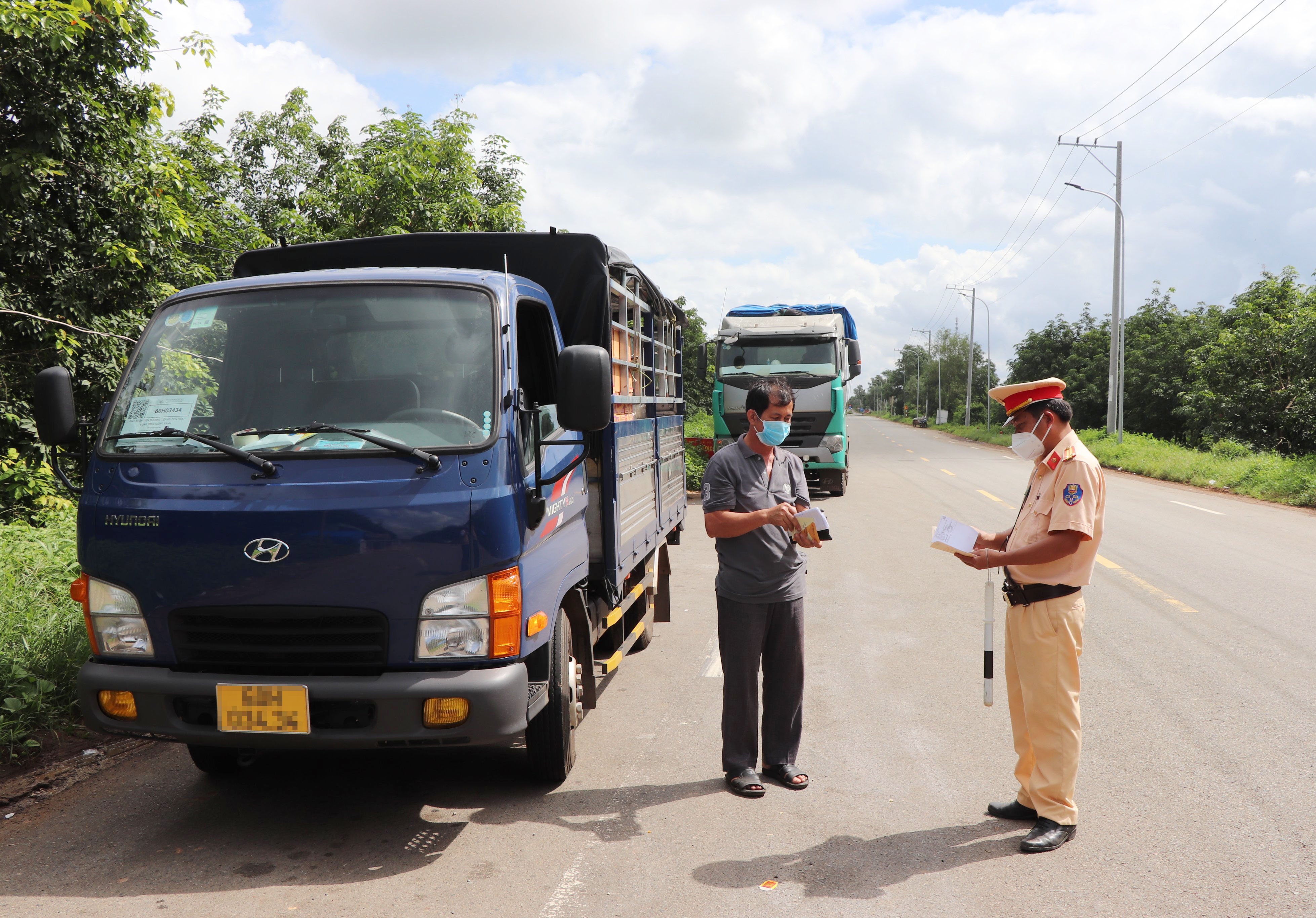 CSGT - Công an huyện Châu Đức kiểm tra giấy tờ đi đường của một tài xế xe tải lưu thông hướng Đồng Nai vào tỉnh Bà Rịa - Vũng Tàu trên đường 765. Ảnh: ĐINH HÙNG