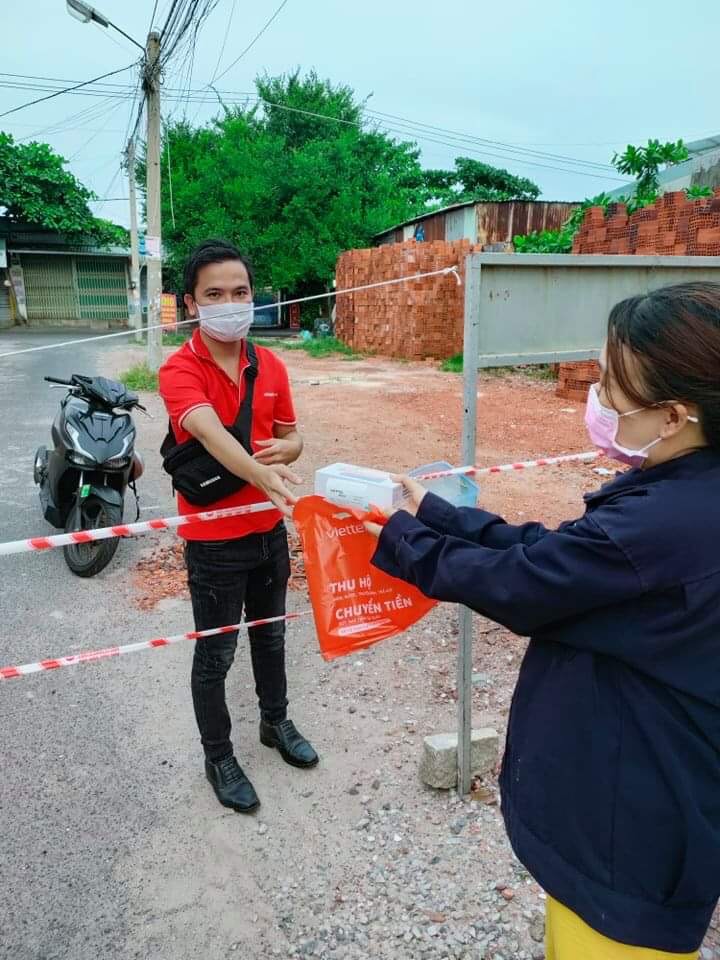 Chị Lê Thị Tám nhận chiếc điện thoại từ shiper do cô giáo và phụ huynh tặng.