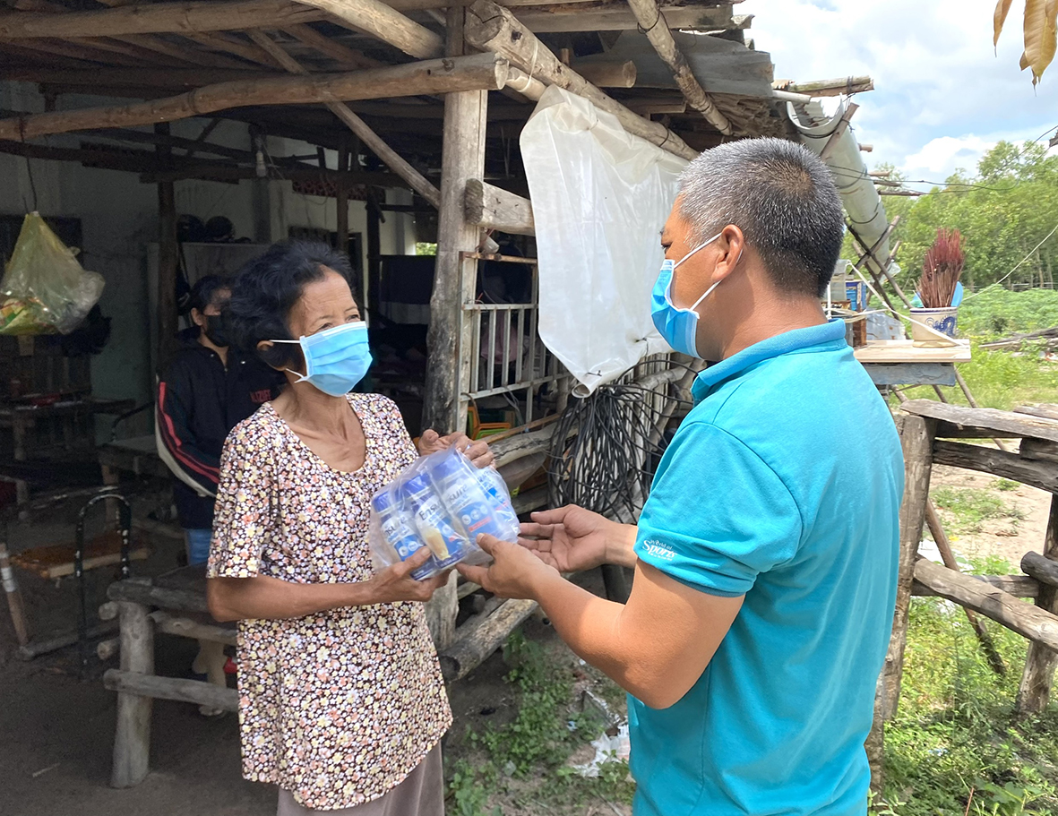 Ông Võ Minh Cường tặng sữa cho một người già có hoàn cảnh khó khăn ở thôn Phước Thành, xã Tân Hòa.