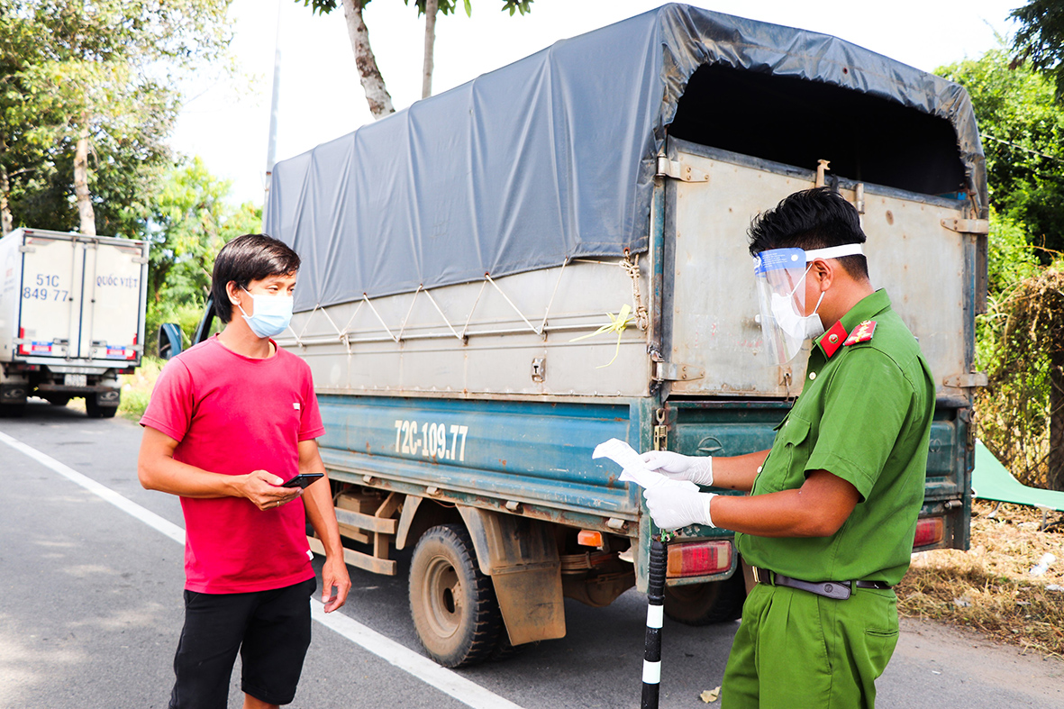 Công an huyện Long Điền kiểm tra giấy đi đường của một tài xế xe tải lưu thông qua Chốt kiểm soát dịch trên QL55 (vòng xoay Vũng Vằn).