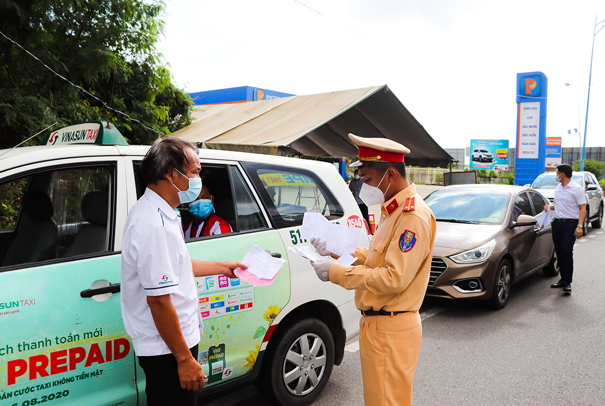 CSGT Công an huyện Long Điền kiểm tra giấy đi đường của một tài xế xe taxi lưu thông qua Chốt kiểm soát dịch trên QL55 (vòng xoay Vũng Vằn).