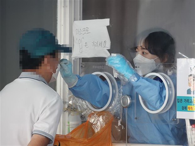 Nhân viên y tế lấy mẫu xét nghiệm COVID-19 cho người dân tại Seoul, Hàn Quốc.