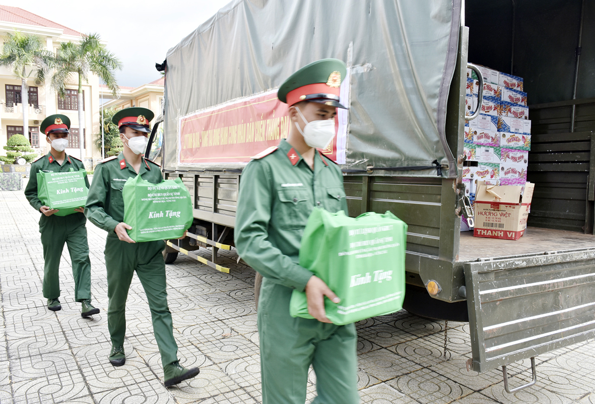 Chiến sĩ Bộ CHQS tỉnh chuyển các phần quà lên xe để đưa đến người dân.